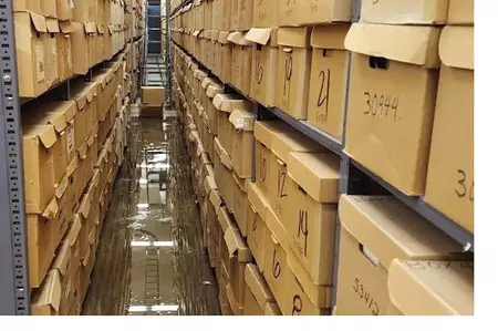 Photo showing a section of wet boxes and floor due to a flood at the Colorado State Archives in December 2022.