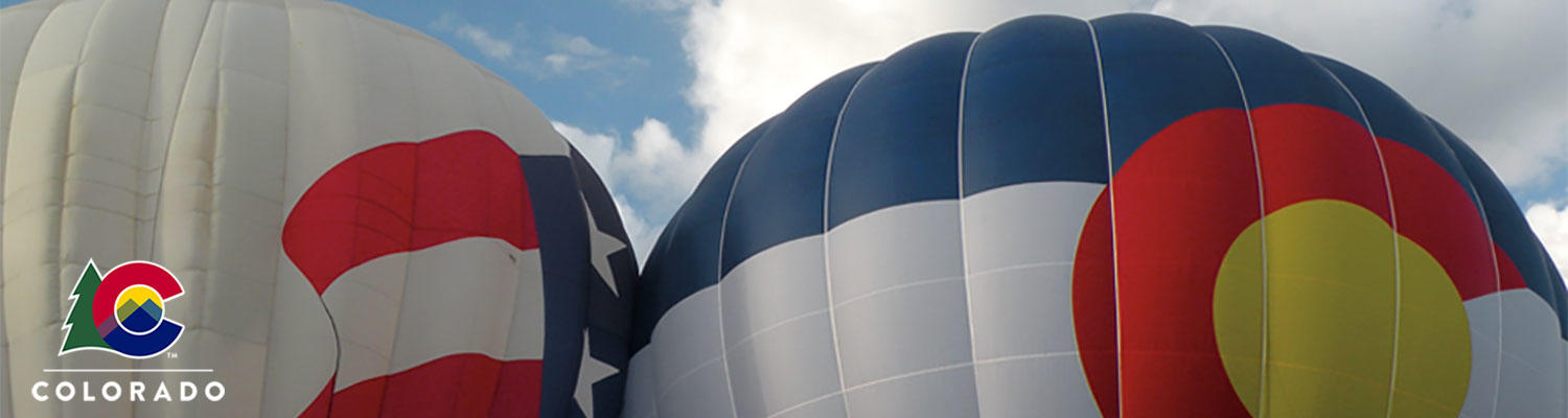 Two hot air balloons with a us flag on one and a colorado flag on the other