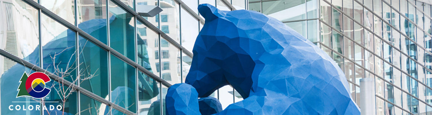 Colorado's big blue bear statue looking in glass windows