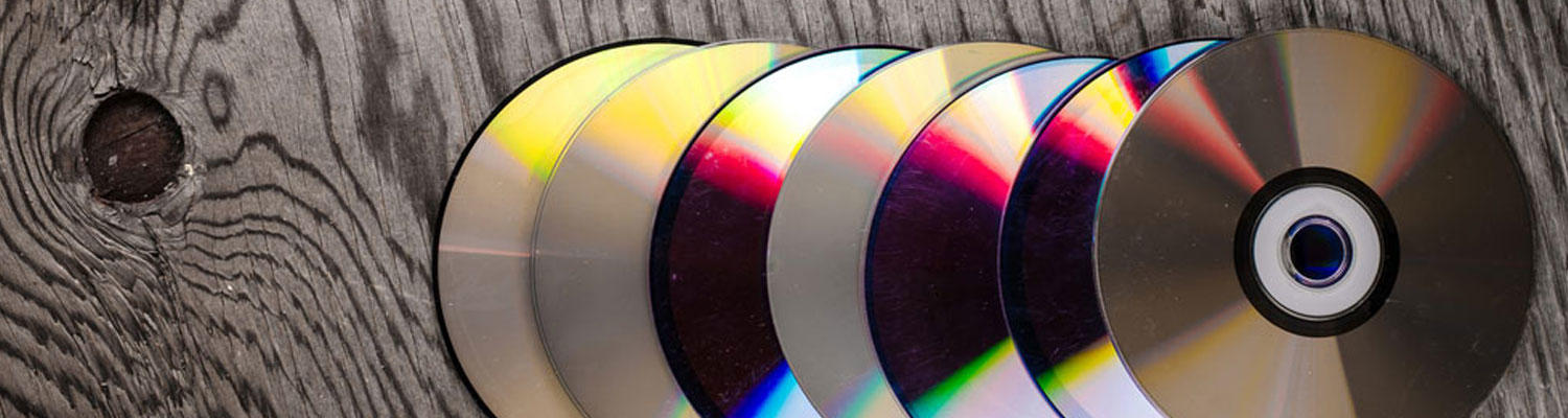 Set of CDs or DVDs on a wood background